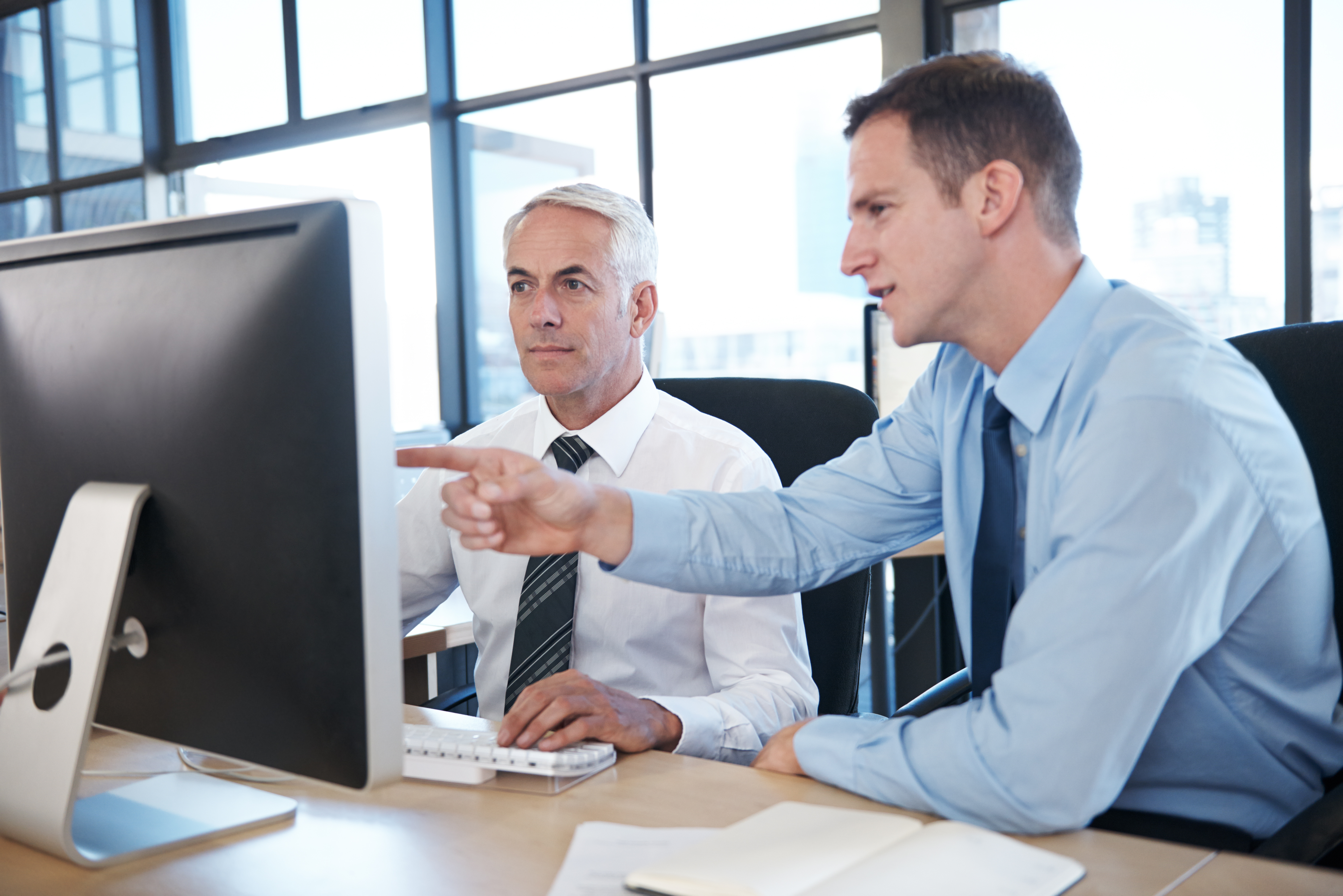 Two colleagues reviewing a candidate assessment on screen together