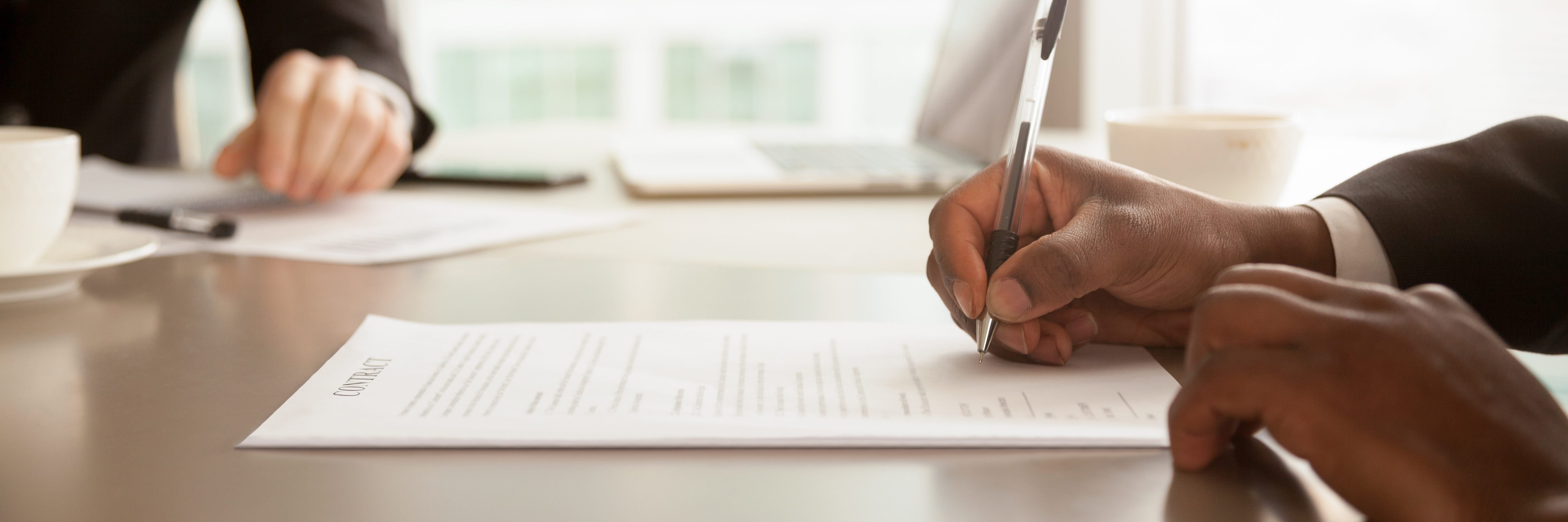 Close-up of a candidate signing a contract — a hiring process reaching a fast, confident close