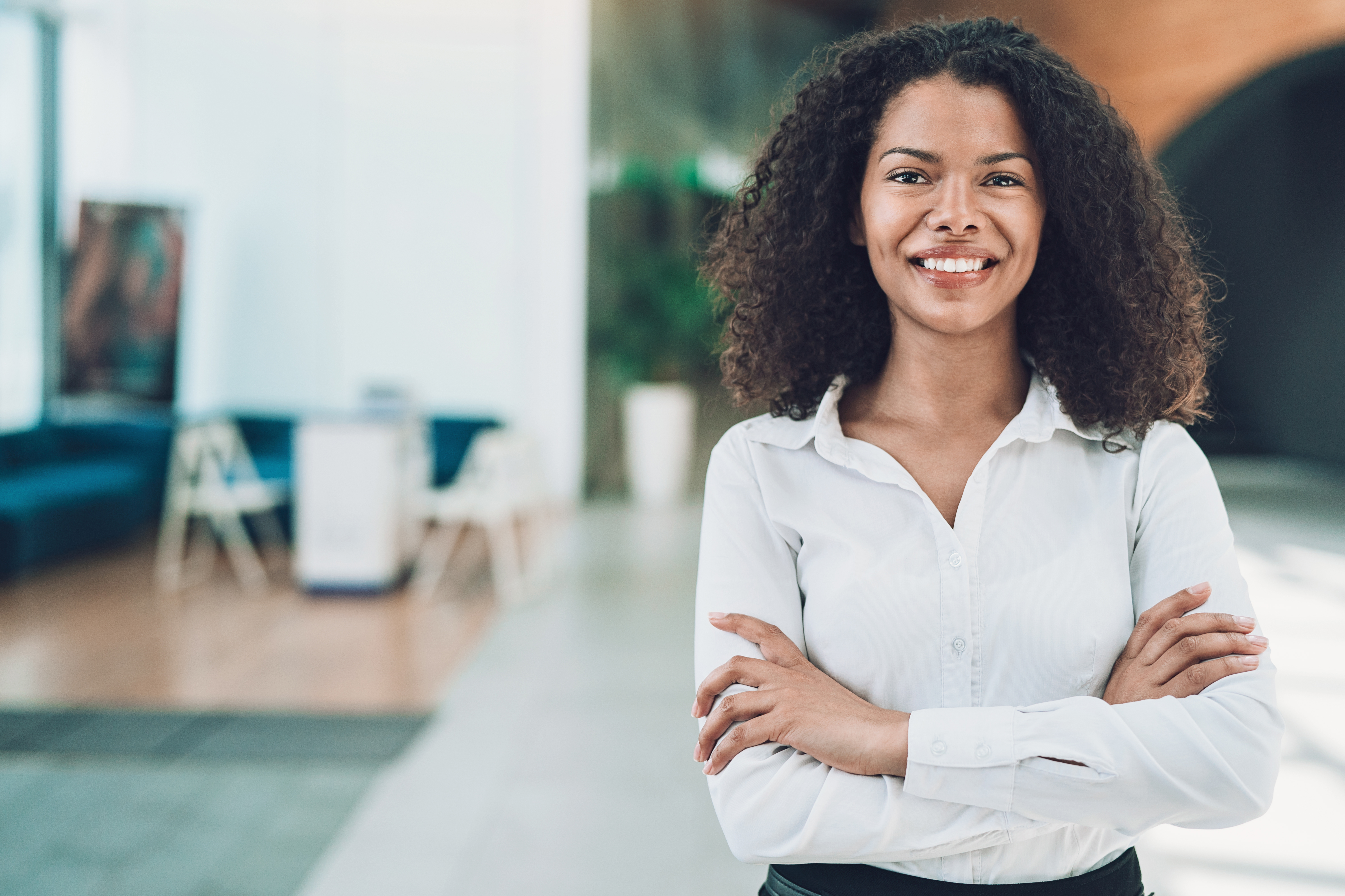 Confident woman, arms crossed, smiling — candidate photo for Colibrí Empower