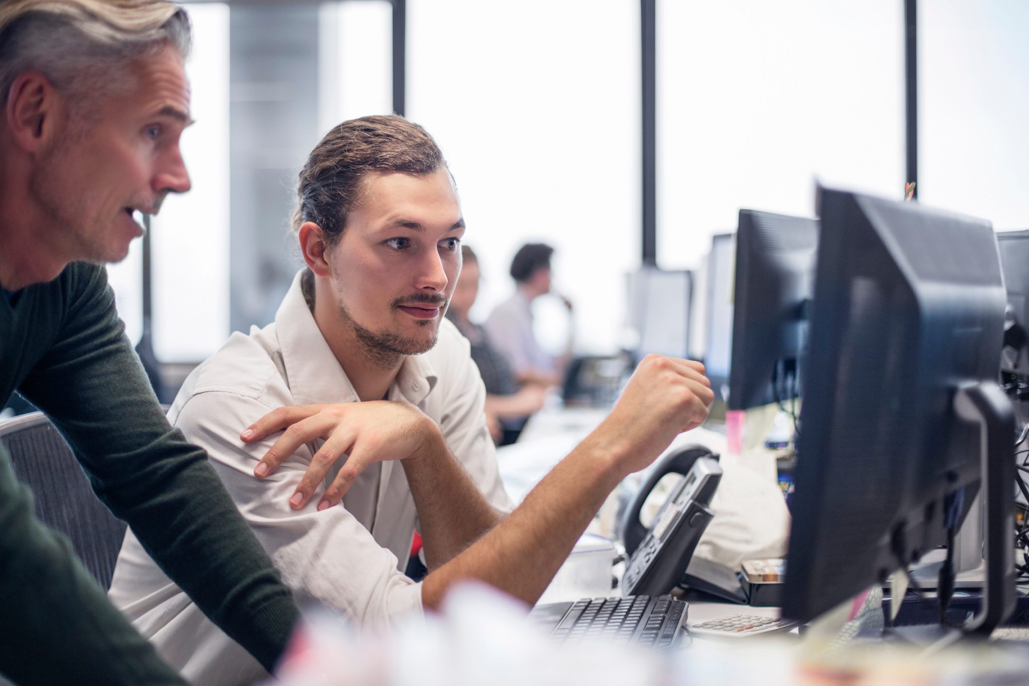 Senior colleague mentoring a consultant at their desk — candidate photo for Colibrí Sky